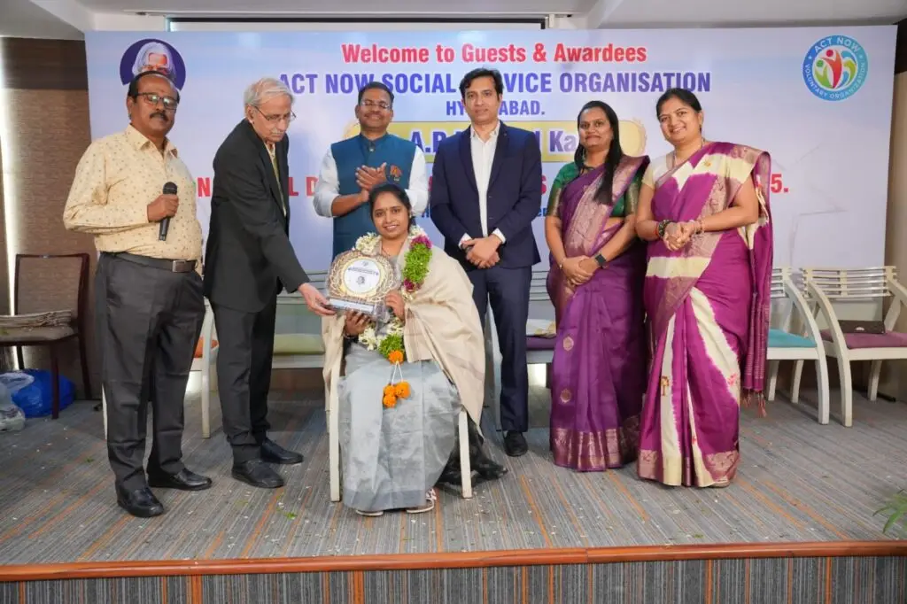 Dr. Akhila Reddy Regatte being honored on stage at the ACT NOW Social Service Organization event in Hyderabad. She is wearing a ceremonial shawl and garland while receiving the "Excellence in Endocrinology Award" from a panel of distinguished guests.